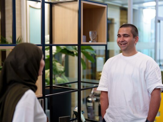 Image of two TSP trainees standing talking to each other.