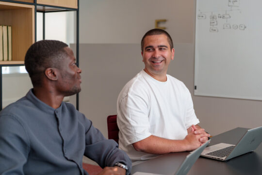 Image of two TSP trainees sitting at a desk, smiling.