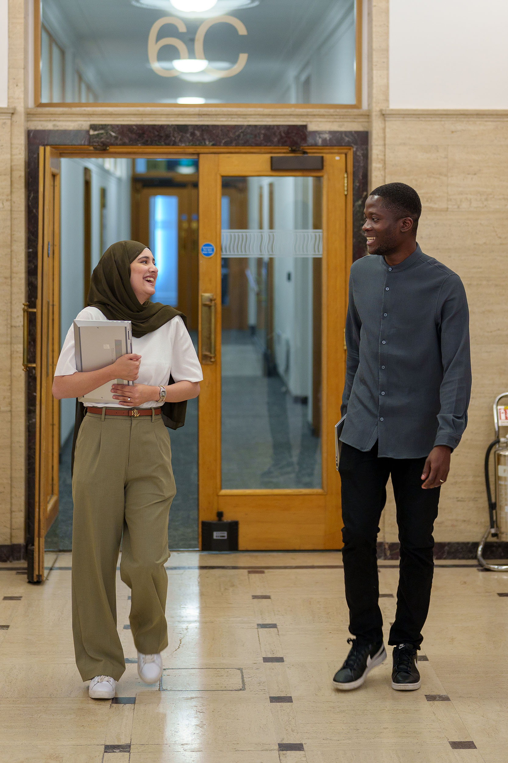 Image of two TSP trainees walking down a corridor in the HMRC Liverpool office.