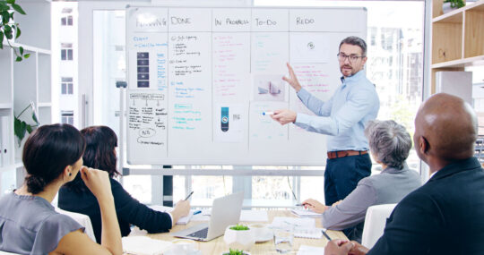 Presentation, discussion and businessman with whiteboard in office for project analysis with team. Meeting, collaboration and speaker with employees for checklist with corporate workshop training