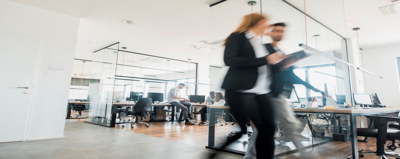 Image of an office with people walking past