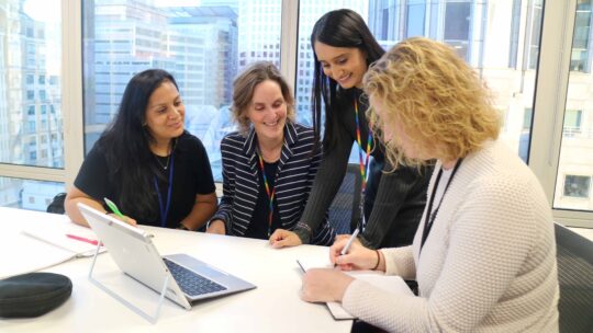 Four colleagues working together around a table