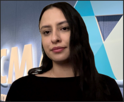 A photo of Katie. She has long dark hair and is wearing a black top