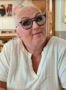 Michelle wearing glasses, sitting looking at the camera