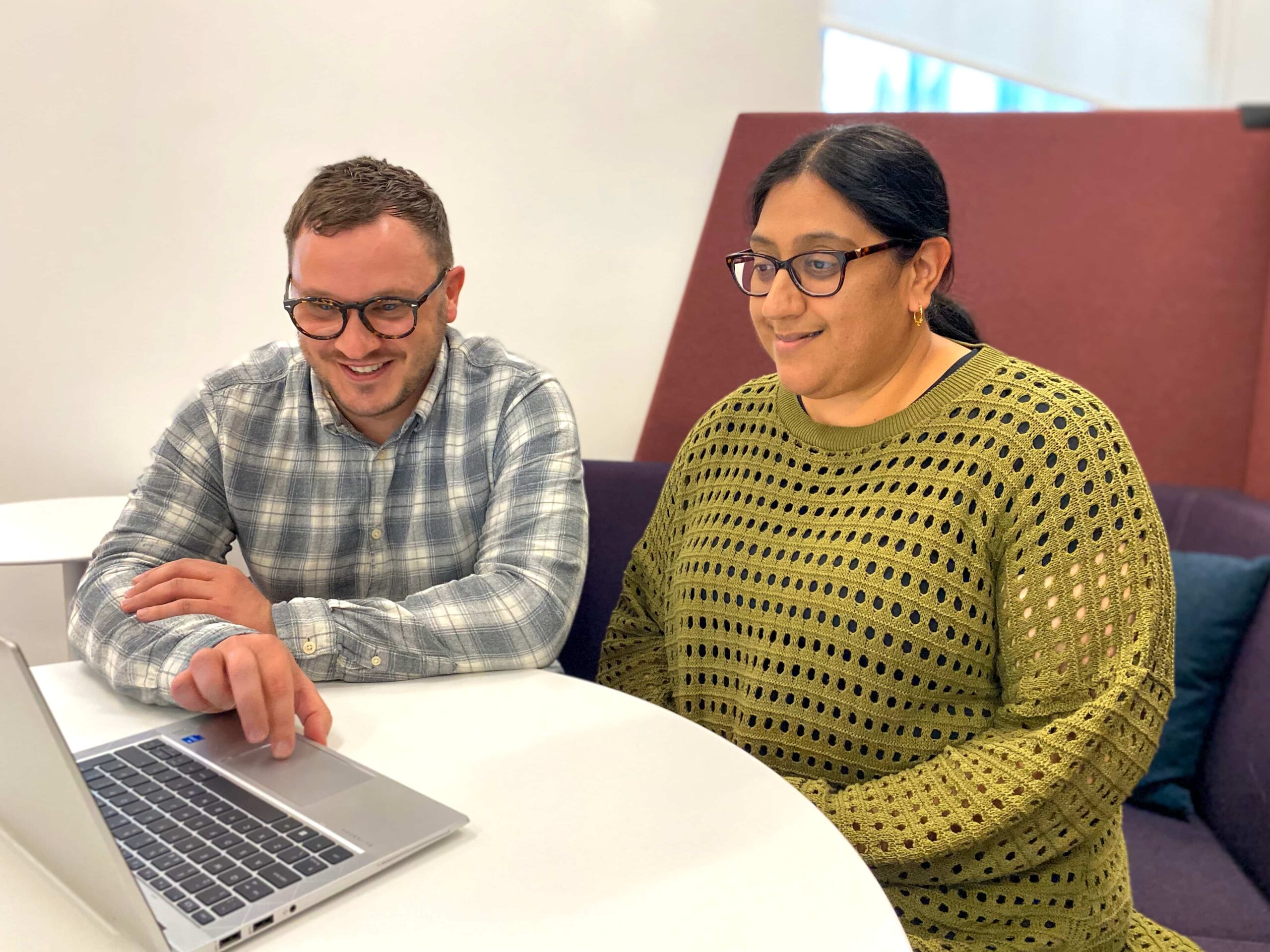 two colleagues sat looking at a laptop