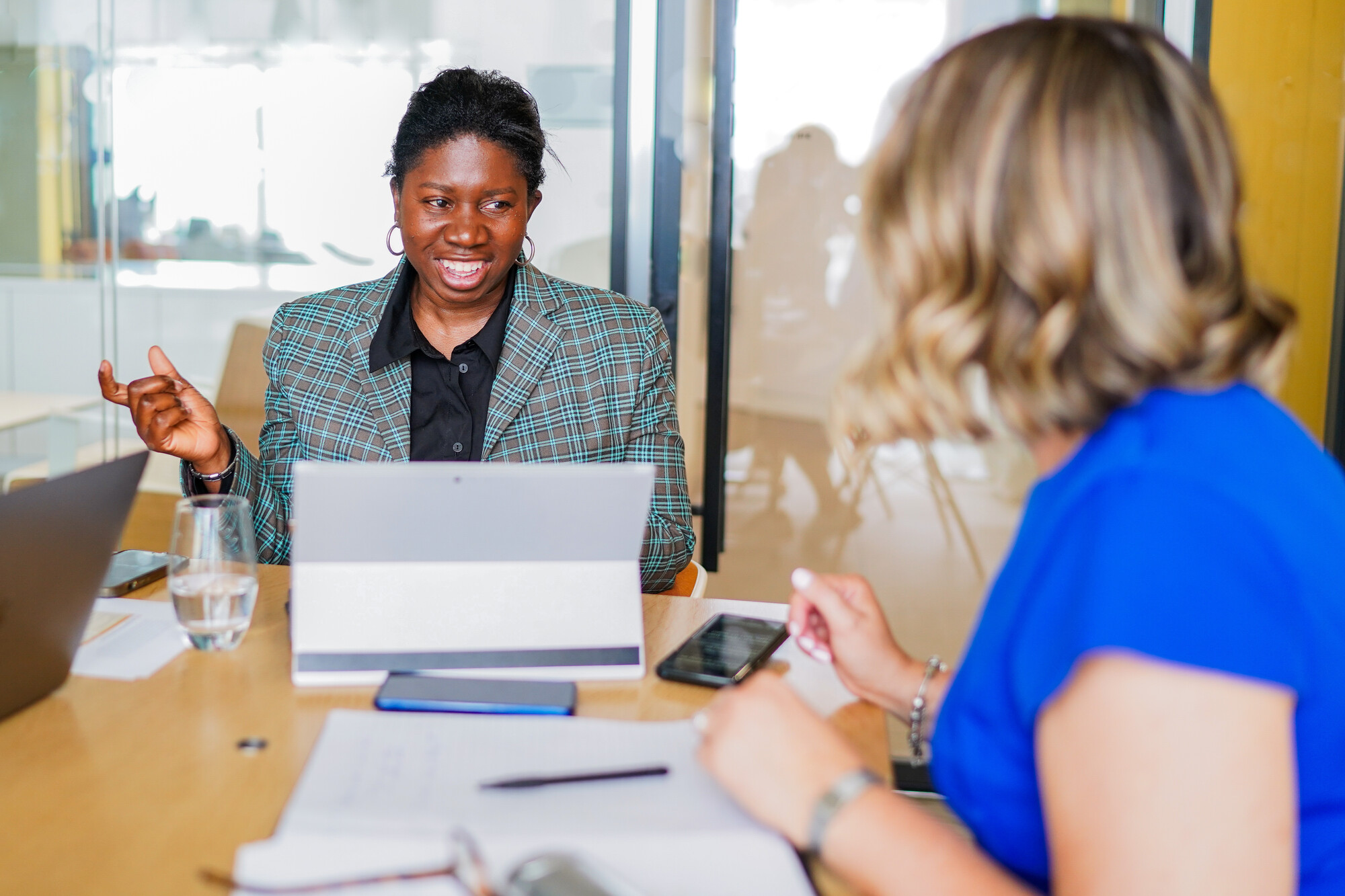 Two (2) colleagues with less-visible disabilities in a meeting together.