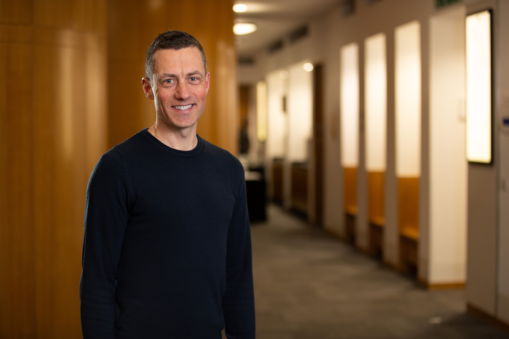 Thomas Beautyman wears a dark coloured sweater and smiles at the camera