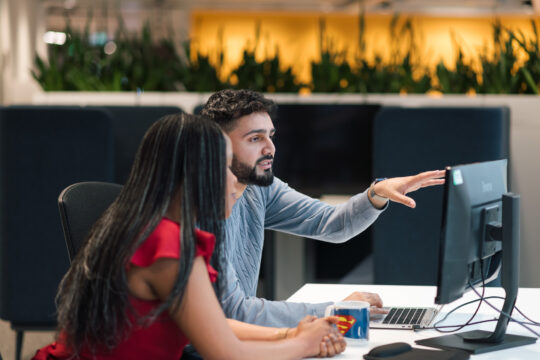 Two colleagues looking at a computer screen.