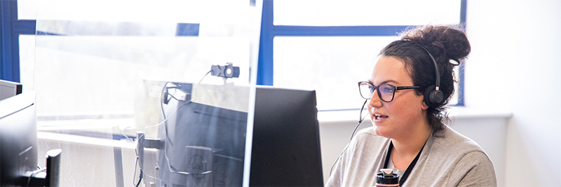 A member of the DVLA Operational and Customer Service Directorate (OCSD) using a headset to answer a call.