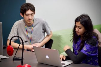 A man and a woman working on a laptop together