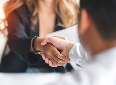 Decorative image: A man and a woman shaking hands, they are both professionally dressed but their faces are out of frame.