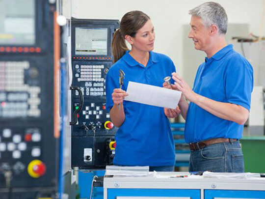 Two engineers discussing tools in production at VCA.