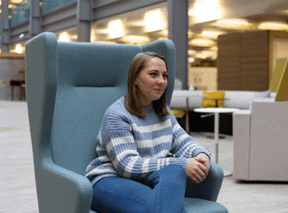 Woman sat in arm chair in a relaxed working environment