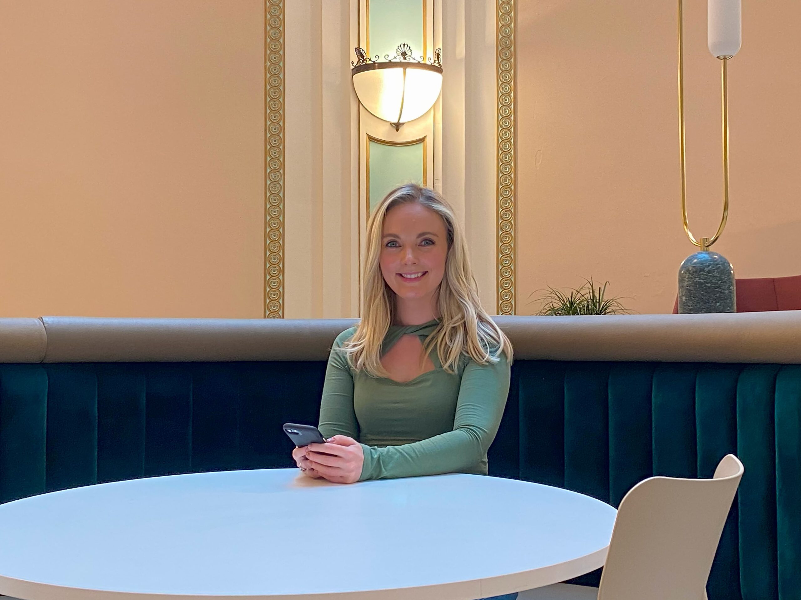 woman sat at a desk smiling at camera