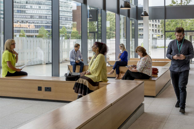 A photo of the Croydon Regional Centre Foyer. It is open and light and several colleagues are standing and sitting chatting.