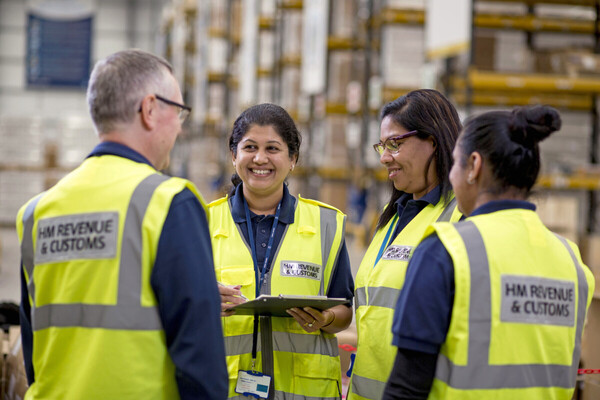 An image of workers in a warehouse, they are wearing hi-vis vests.