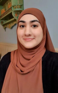 Photo of Hafsah Butt from Department for Culture, Media and Sport. She is wearing a dark top and a light brown hijab.