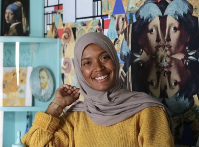 Photo of Cylina Addai, she is wearing yellow sweater and a hijab, and is smiling