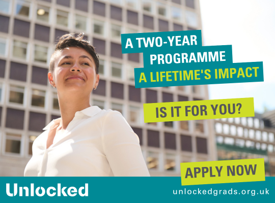 A graduate stands proudly in front of a building. The Unlocked graduates banner says 'apply now' with the tag line: "A two year programme, a lifetime's impact. Is it for you?"