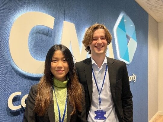 Two interns standing together and smiling