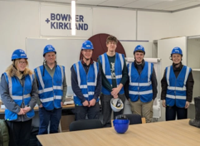 Image of Isaac on his placement, with a large group of students, all wearing high vis jackets and hard hats.