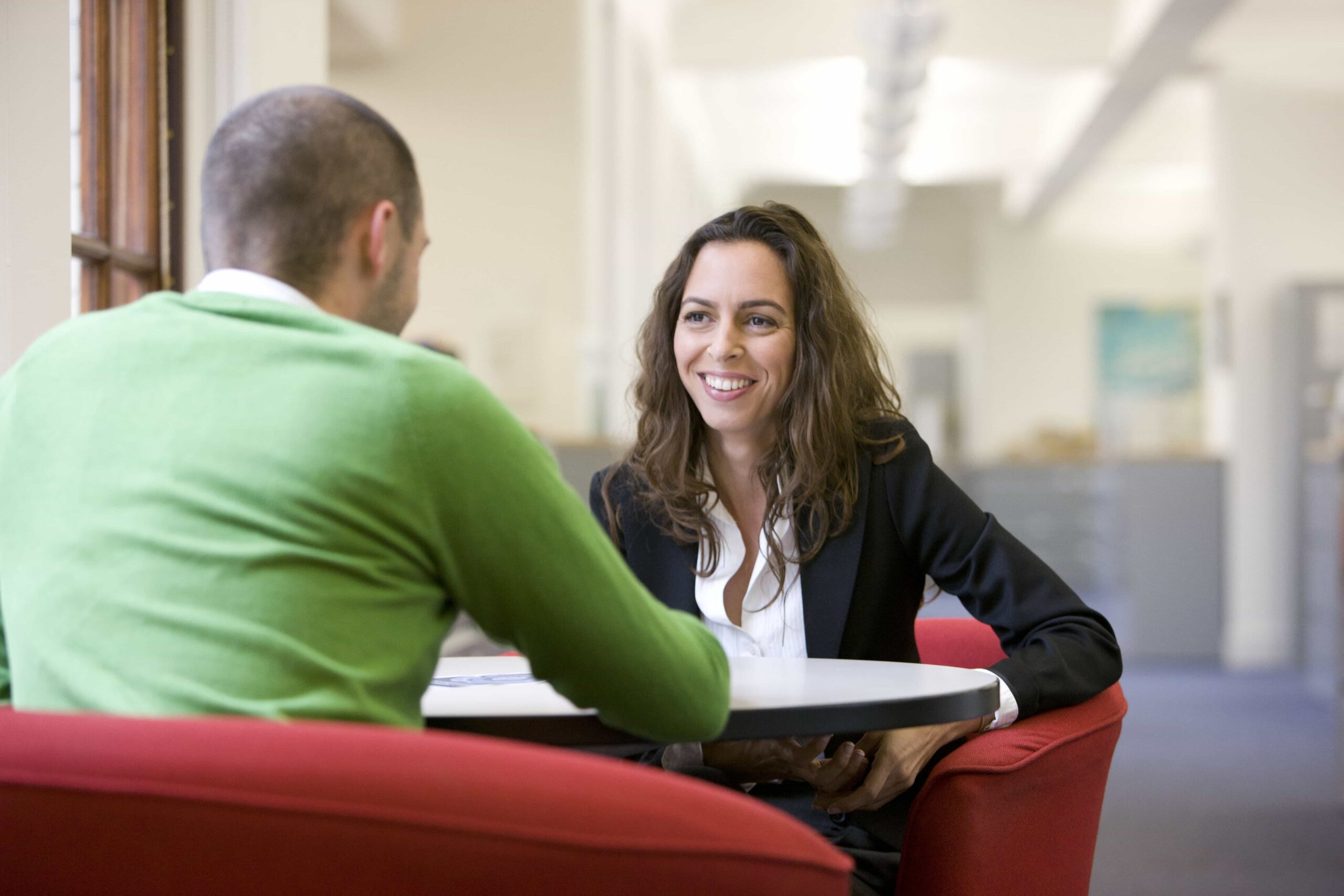 A man and woman sat at a table talking