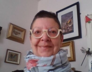 Photo of Martine Vatcher a Resourcing Consultant For HM Passport Office. She has short dark hair and is wearing stylish glasses and pastel chiffon scarf