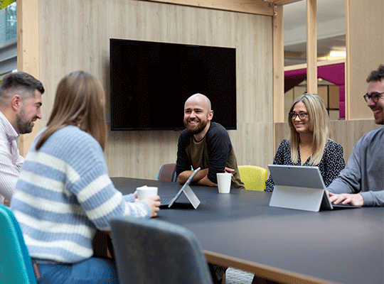 employees sat around desk workings and talking