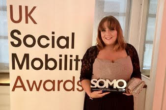 Decorative image - Photo of Nikki Hanmner: she is holding an award, the banner behind her reads 