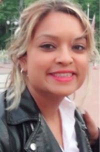 A photo of Ghaitree Mungroo. She has blonde hair and is wearing a leather jacket, and pink lipstick