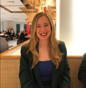 Photo of Miriam Parker. She is wearing a black suit jacket and has long blonde hair