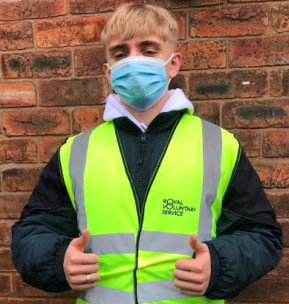 Photo of Daniel Hickman - he is wearing a hi-vis vest and a disposable facemask. He's giving a thumbs-up.