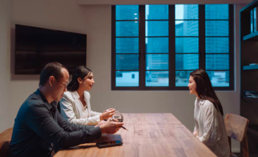 Decorative image: A man and a woman interviewing another woman, who is sitting across the desk from them.