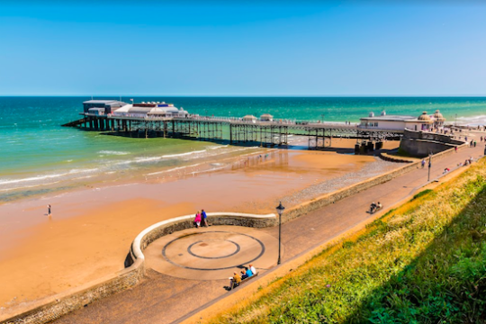 A pier on a beach in the East of England, in the sunshine