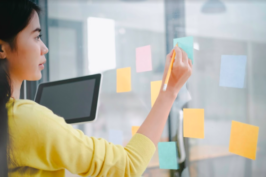 A colleague writing on post-it notes on a wall