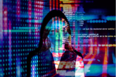 A woman overlaid with the reflection of city buildings outside, they are lit up in the dark.