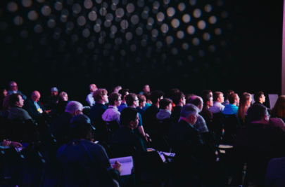 A group of people sitting in an auditorium listening to an out-of-shot speaker