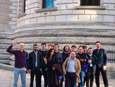 A team of people outside in front of an impressive round building