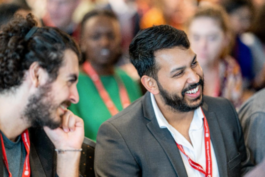 Two men at a networking event, smiling and talking