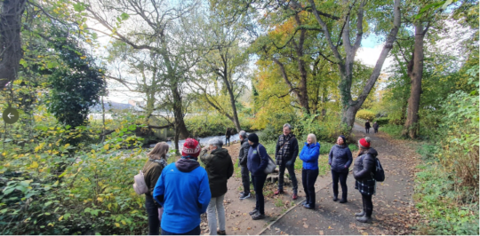 A group of people outside, surrounded by trees. They're dressed for winter walking.