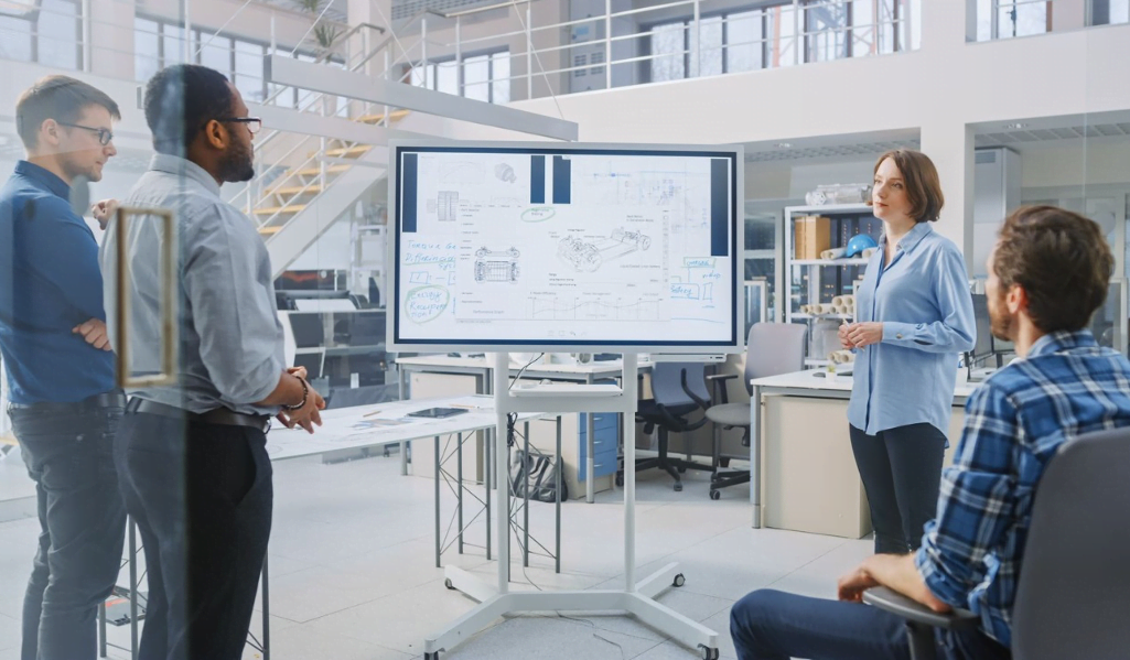 Decorative image: a group of four colleagues working together on a whiteboard