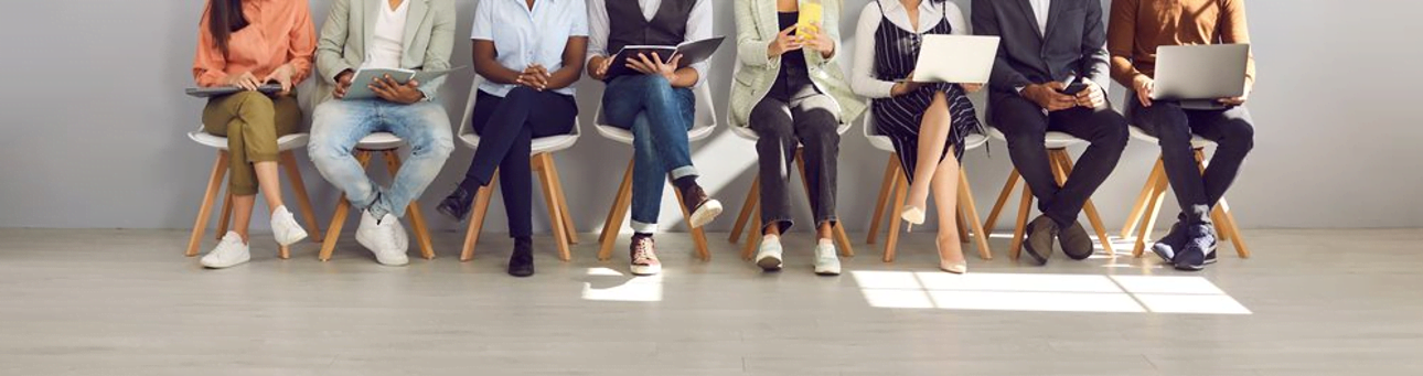 Decorative image: a photo of people from the waist down, sitting in chairs in a row.