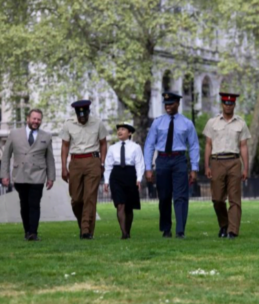 Decorative image: four people walking in a park, they are in various military uniforms