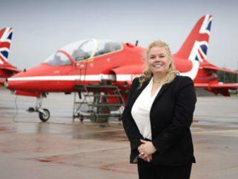 Decorative image: a photo of Helen, a MoD employee, standing on an airfield in front of a plane