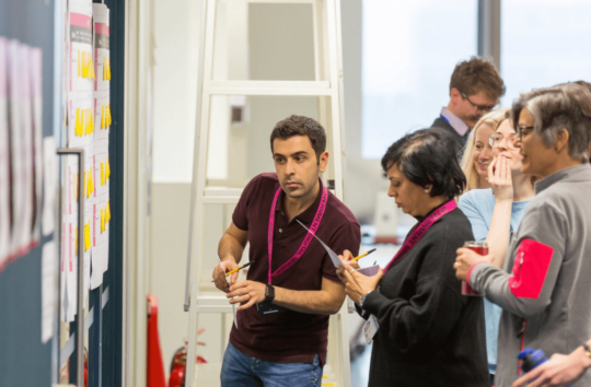 Decorative image: a team working on a whiteboard together