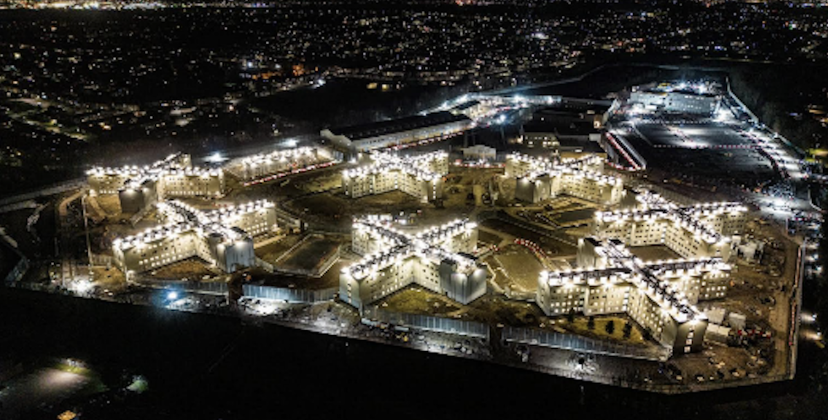 A large prison building, lit at night