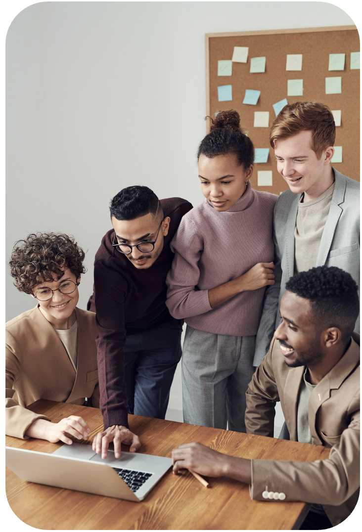 a diverse group of colleagues huddle around a laptop