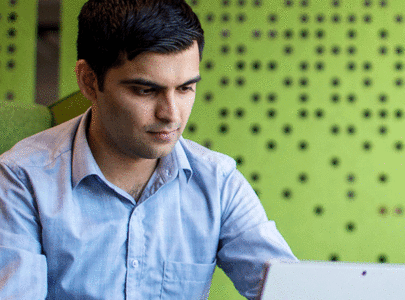 close up of man looking at laptop screen in office