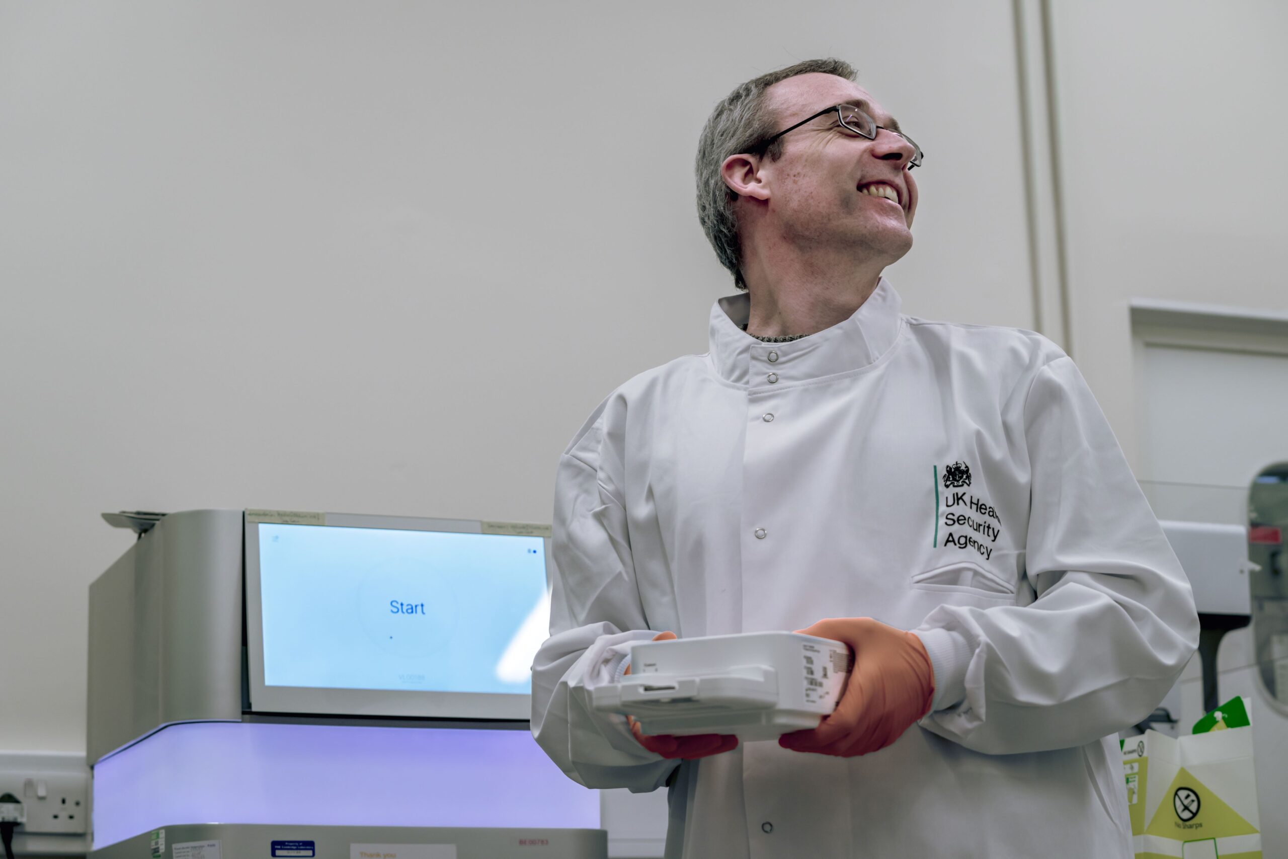 Scientist smiles as he works with a technical device