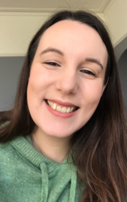 Verity smiling at the camera wearing a green jumper